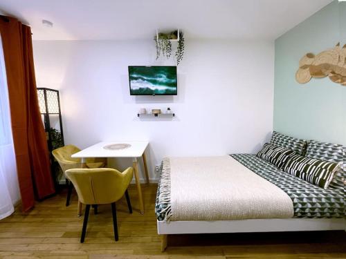 une chambre avec un lit, un bureau et une table dans l'établissement Le Central • Hyper Centre • Proche Gare • Fibre, à Châteauroux