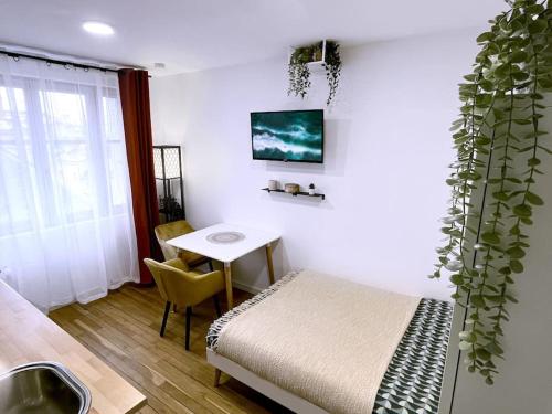 - une chambre avec un lit, une table et une plante dans l'établissement Le Central • Hyper Centre • Proche Gare • Fibre, à Châteauroux