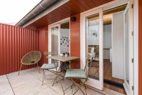 a patio with a table and chairs on a balcony at Rua de Tr&aacute;s Apartments in Porto
