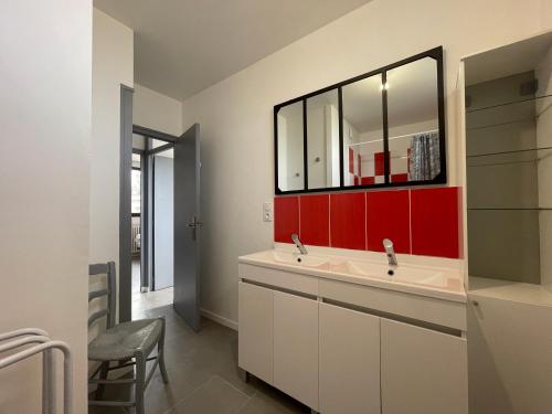baño con lavabo y pared roja en Grand appartement en vallée de la loire, en Gennes