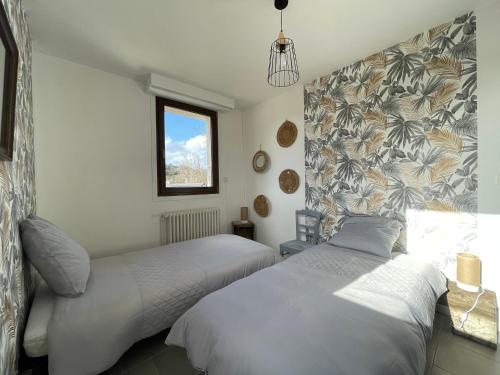une chambre avec deux lits et une fenêtre dans l'établissement Grand appartement en vallée de la loire, à Gennes
