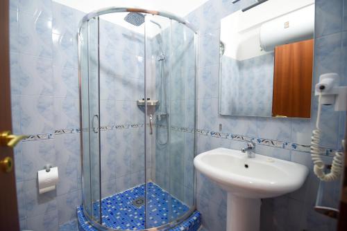 y baño con ducha y lavamanos. en Hotel Vivas en Durrës