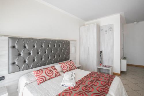 a bedroom with a large bed with red and white pillows at Hotel Playa in Viareggio