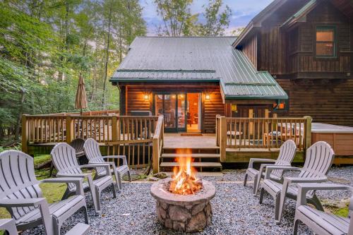 a fire pit in front of a log cabin at Jamesons Cabin! 8 Minutes to Wisp, HotTub, FirePit, Pets, EV Chgr in Oakland