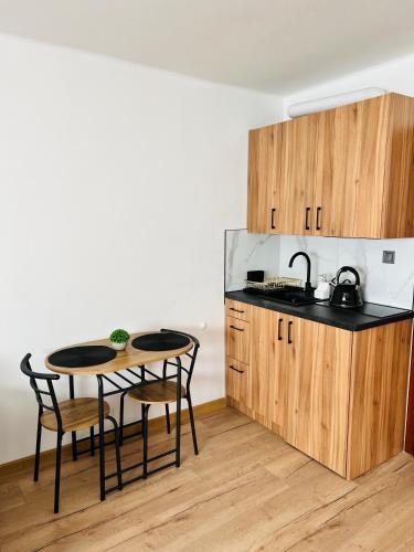 a kitchen with a table and two chairs and a sink at Apartament Kolejowa 7 in Nowy Targ