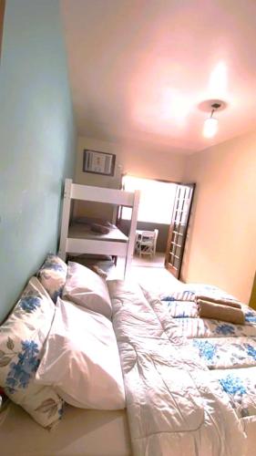a bedroom with an unmade bed and a table at Pousada Praia do Recreio in Rio de Janeiro