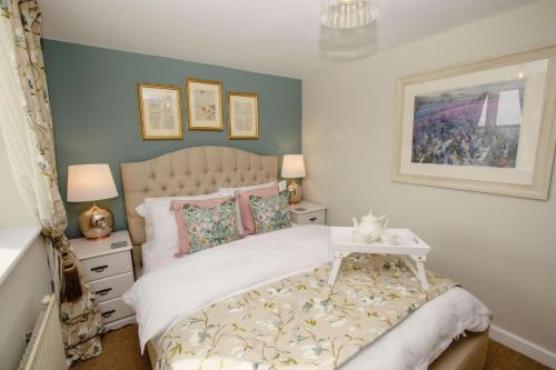 ein Schlafzimmer mit einem Bett, einem Nachttisch und einem Tisch in der Unterkunft Shepherds Cottage - Rudge Farm Cottages in Bridport