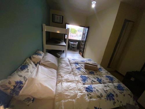 a bedroom with a bed with blue flowers on it at Pousada Praia do Recreio in Rio de Janeiro