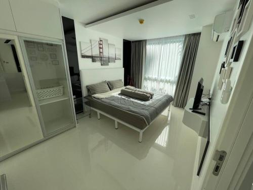 ein Wohnzimmer mit einem Bett und einem Spiegel in der Unterkunft Stylish Condo with pool, sauna, steam room & gym in Pattaya