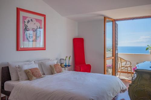 a bedroom with a large bed with a view of the ocean at Donna Rachele in Aci Castello