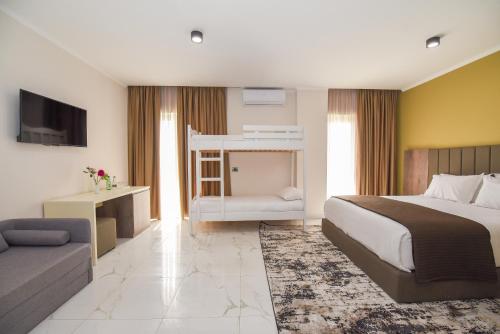 a hotel room with a bed and a couch at Hotel Vivas in Durrës