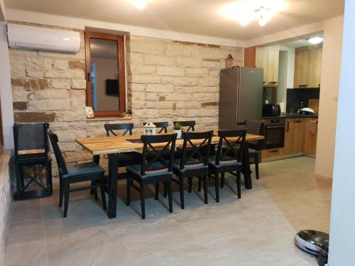 a kitchen with a wooden table and black chairs at Ракшиева Къща in Glavatartsi