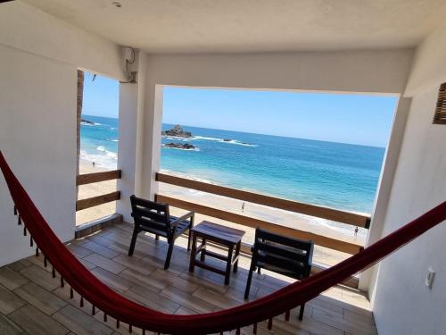 a balcony with a hammock and a view of the ocean at Posada Ziga Playa in Mazunte