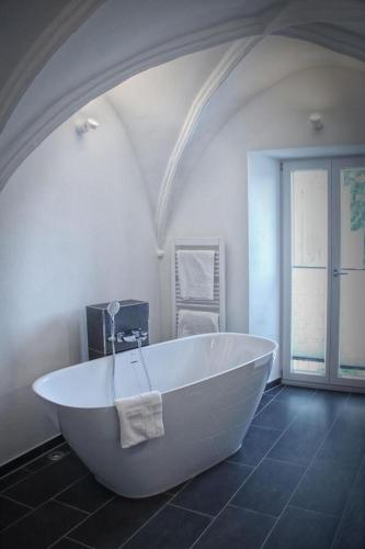 a large white bath tub in a room with an attic at Landhotel Schlappinger-Hof in Reisbach