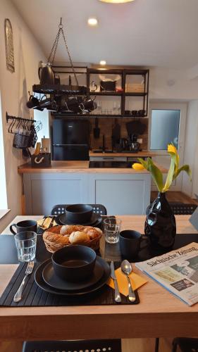a kitchen with a table with black plates and utensils at alte Bäckerei Bautzen - 04 #Business# in Bautzen
