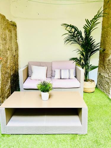 a white bench with pillows on it on the grass at Loft centro Pontevedra in Pontevedra
