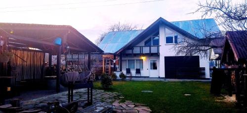 una casa bianca con tetto blu e cortile di GONTA cottage a Slavske