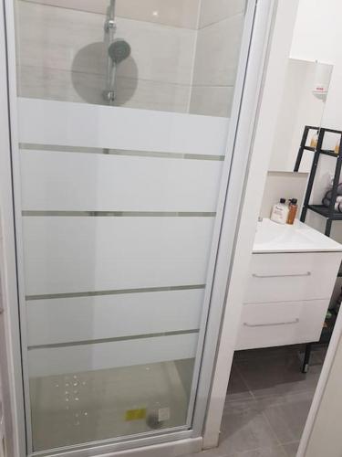 une douche avec une porte en verre à côté d'un bureau dans l'établissement Cozy Apartment, Airport CDG Exhibition Parc 14 min, à Tremblay-en-France
