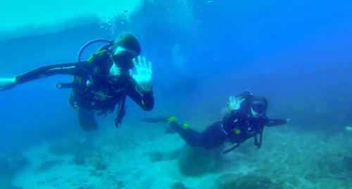 two people swimming in the water in the ocean at Venha Juntos Guest Homes in Miramar