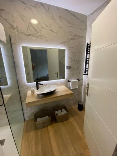 uma casa de banho com um lavatório e um espelho em Marola 18 - Salinas em Salinas