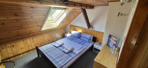 1 dormitorio con 1 cama azul en una cabaña de madera en Pension Pod Kaštany Srbská Kamenice, en Srbská Kamenice