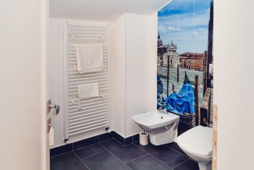 a bathroom with a toilet and a sink and a window at Casa Del Sole in Alba Iulia