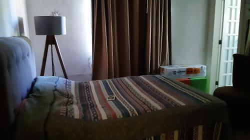 ein Schlafzimmer mit einem Bett mit einer Steppdecke darauf in der Unterkunft Casa Aconchegante in Saquarema