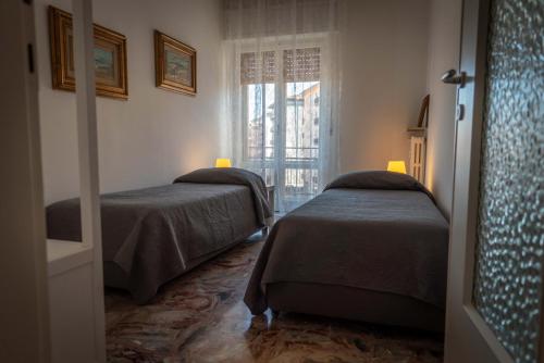 two beds in a room with a window at Afrodite Loft Hermes in Verona