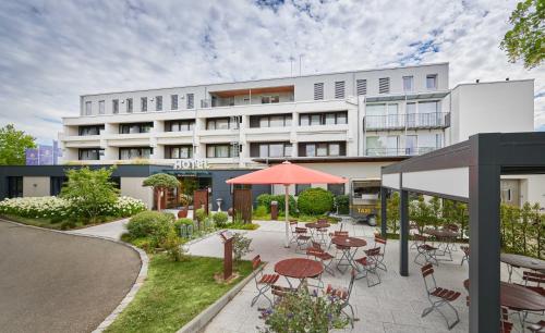 un hotel con mesas y sillas frente a un edificio en Hotel Schönbuch en Pliezhausen