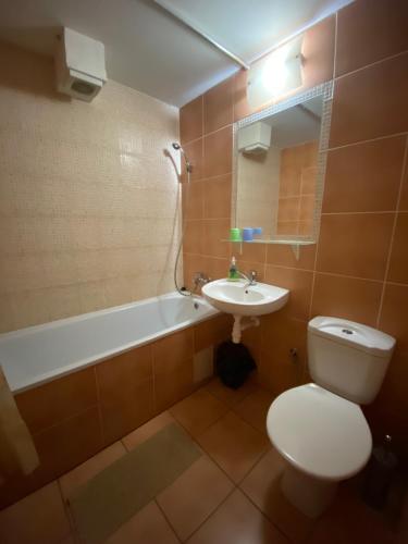 a bathroom with a toilet and a sink and a tub at Hostel CafeRAZY in Poprad