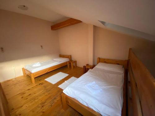 a room with two beds and wooden floors at Hostel CafeRAZY in Poprad