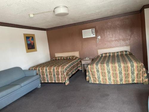 a hotel room with two beds and a couch at Sands Motel in El Paso