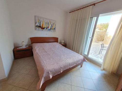 a bedroom with a bed and a large window at Olive garden Pag studio apartment in Pag