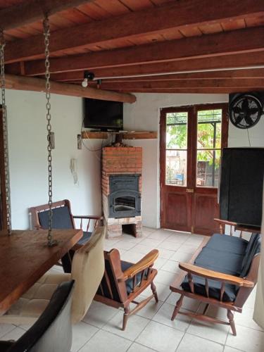 ein Wohnzimmer mit einem Tisch, Stühlen und einem Kamin in der Unterkunft La fortuna in Las Toscas
