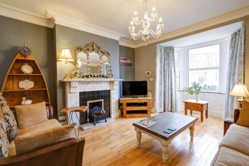 ein Wohnzimmer mit Couch und Kamin in der Unterkunft Seashell House with SEA VIEWS and FREE GYM POOL PASS in Amble
