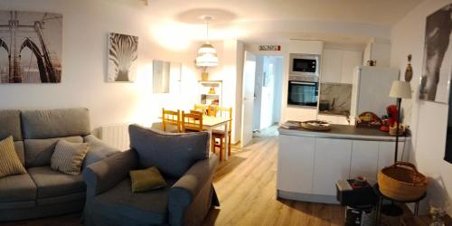 薩拉戈薩的住宿－Suite Lay，厨房以及带沙发和桌子的客厅。