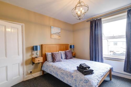 a bedroom with a bed and a window at Seashell House with SEA VIEWS and FREE GYM POOL PASS in Amble