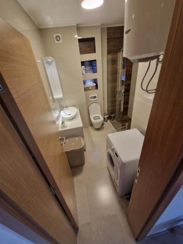 a small bathroom with two toilets and a sink at Apartman Malakal in Lukavica