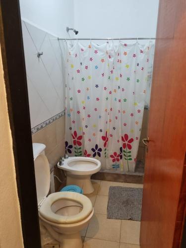 ein Badezimmer mit 2 WCs und einem Duschvorhang in der Unterkunft Nuevos Aires in Corrientes