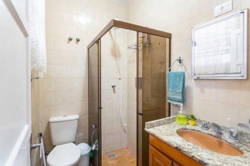 uma casa de banho com um chuveiro, um WC e um lavatório. em Casa charmosa e confortável no Porto Maravilha - quartos disponíveis conforme número de hóspedes no Rio de Janeiro