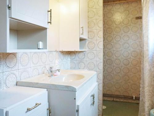 baño con lavabo blanco y armarios blancos en Holiday home Brastad X, en Brastad