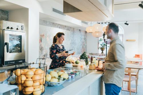 Ein Mann und eine Frau stehen in einer Küche in der Unterkunft Eclectic Hotel Copper in Middelburg