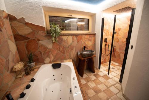 a bathroom with a tub and a stone wall at Bergstern in Freudenstadt