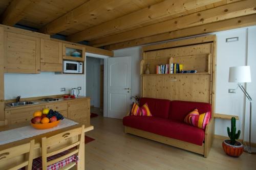 a living room with a red couch in a kitchen at Locanda Tana de 'l Ors in Val di Zoldo