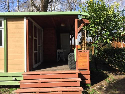 une cabane avec un toit vert et un porche dans l'établissement Beach house à Marina di Sorbo …Corse, à Sorbo-Ocagnano