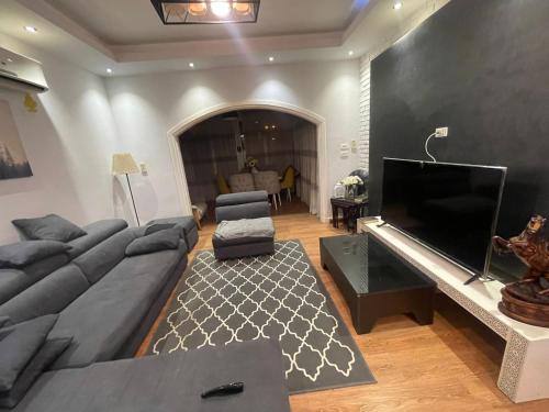 a living room with a couch and a flat screen tv at Apartment for rent in Ramo 6 October in 6th Of October