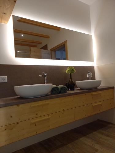 baño con 2 lavabos y espejo grande en Apartment Schönwetter en Großsölk