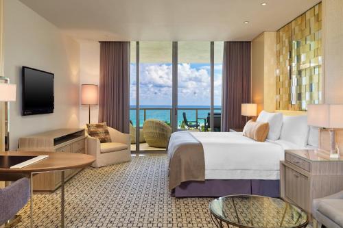 a hotel room with a bed and a view of the ocean at The St. Regis Bal Harbour Resort in Miami Beach
