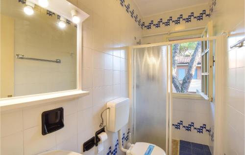 a bathroom with a shower and a toilet and a window at Amazing Apartment In Bibione With Outdoor Swimming Pool in Bibione