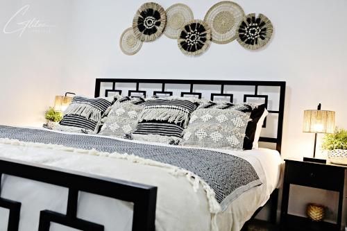 a bedroom with a black and white bed with pillows at BoHo Modern Retreat King Bed,Fireplace,Disney in Edmonton